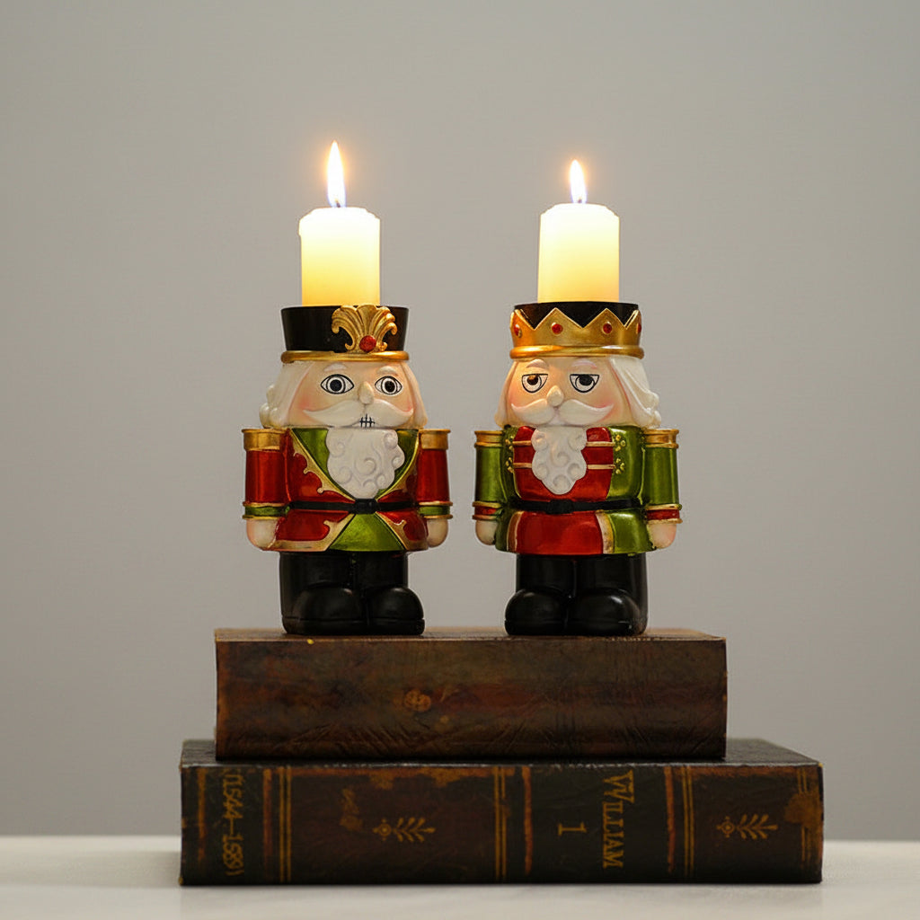Two nutcracker-shaped candle holders with lit white pillar candles, displayed on top of two dark vintage books against a softly blurred beige background.