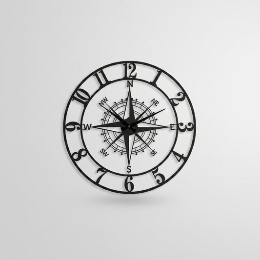 Decorative wall clock with compass design on a white wall.
